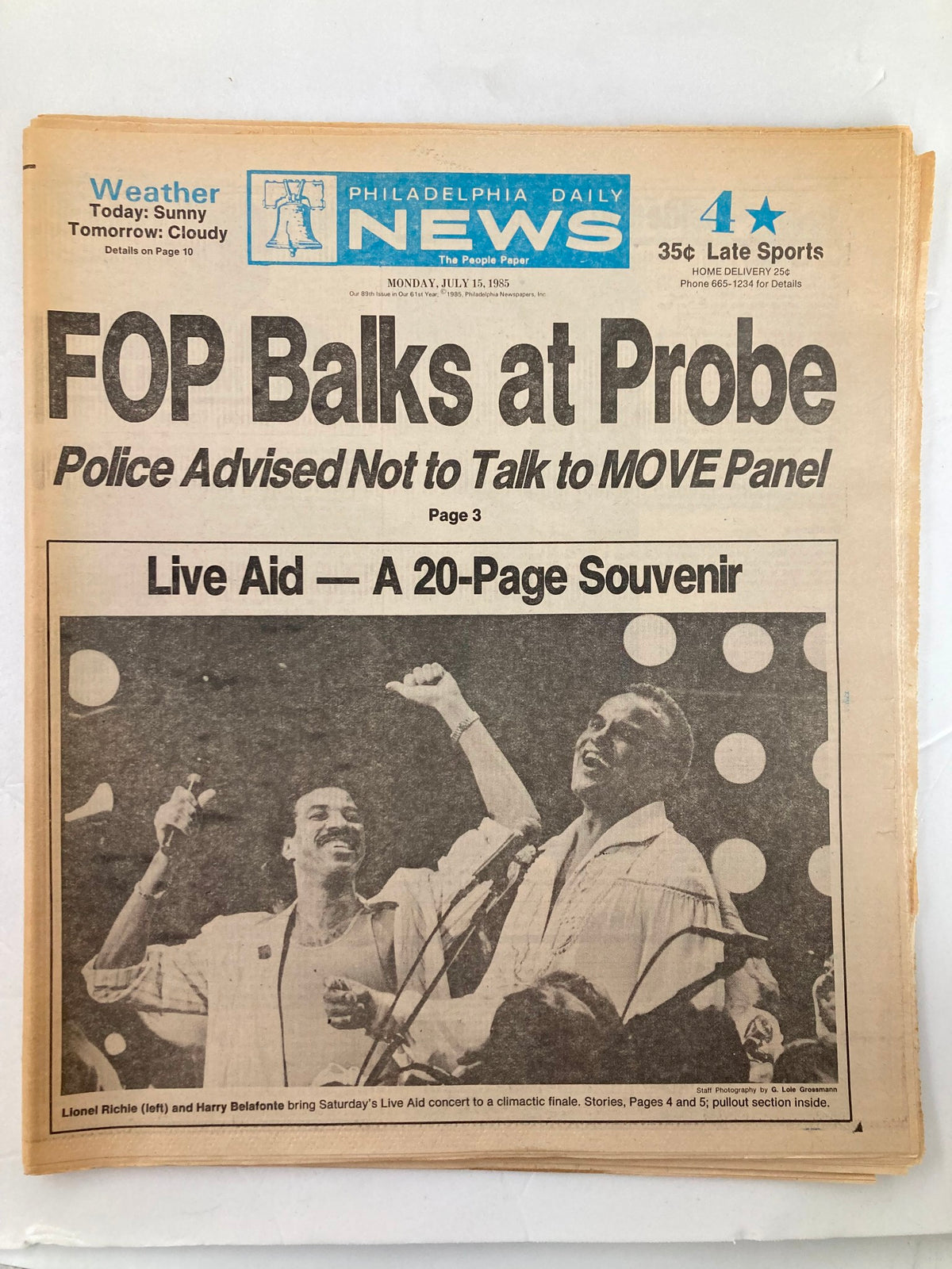 Philadelphia Daily News Tabloid from July 15, 1985 featuring Lionel Richie and Harry Belafonte in a performance during Live Aid. The front page highlights news articles with bold headlines and a vintage design.
