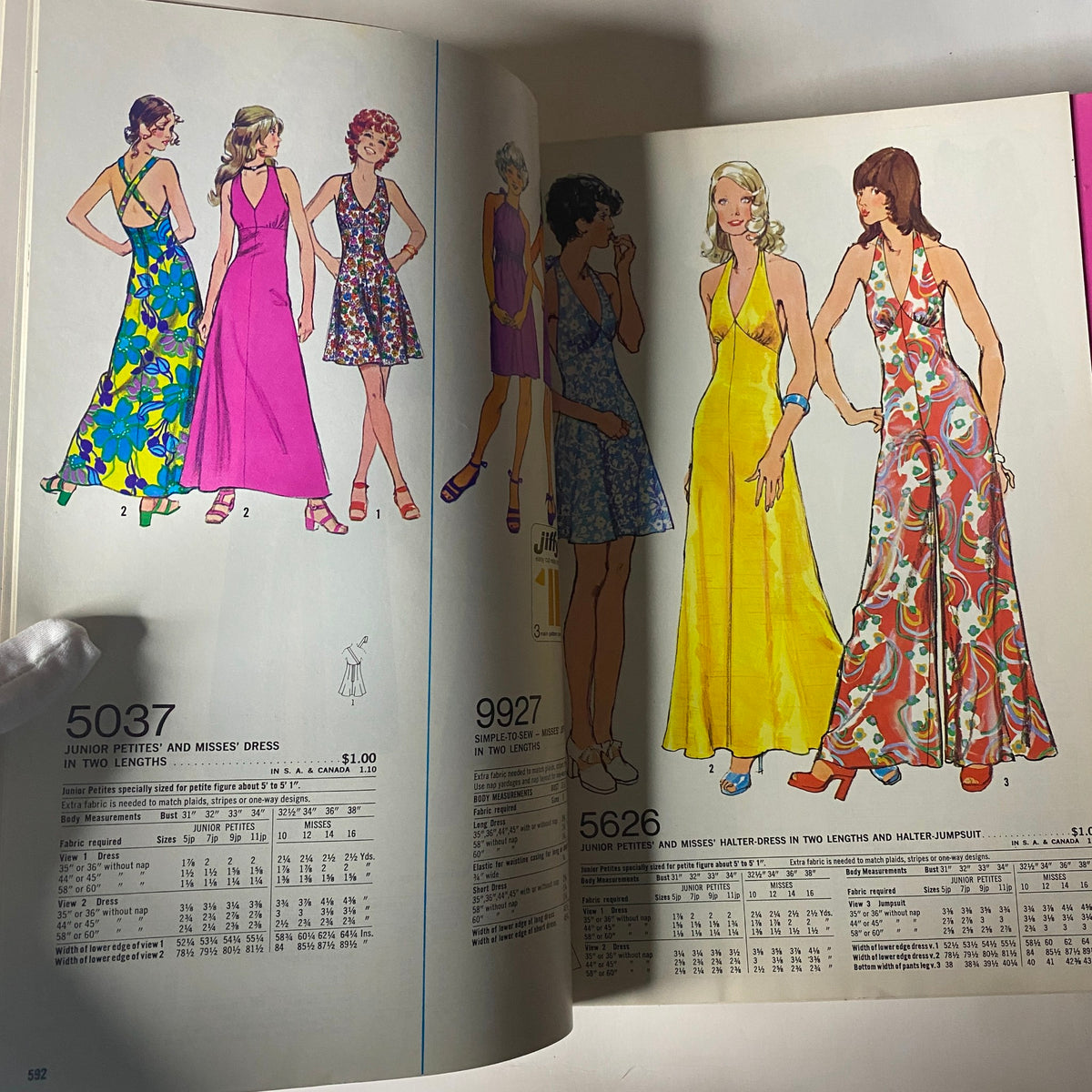1973 July Simplicity Catalog featuring sewing patterns for junior and misses dresses in vibrant colors, highlighting trendy styles for summer dresses and halter jumpsuits.