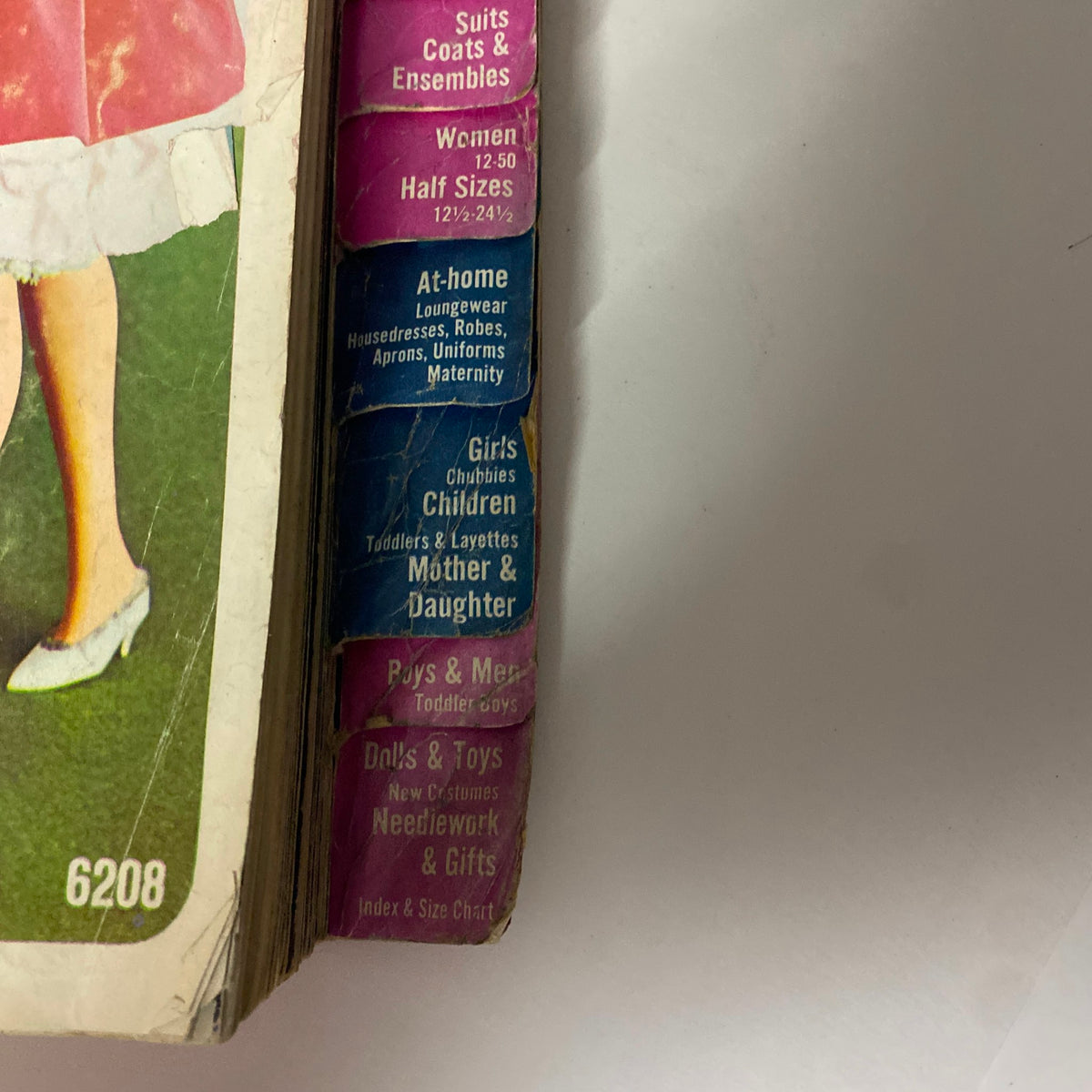 Side view of a page from the 1965 December Simplicity Christmas Catalog, featuring sewing pattern categories such as Suits, Coats, and Ensembles for women and children, along with accessories.