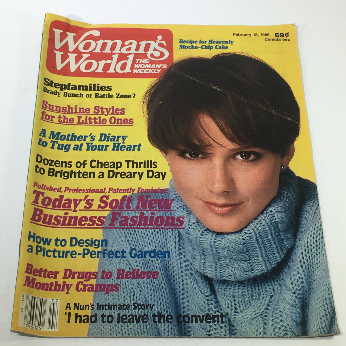 Cover of VTG Woman's World Magazine from February 18, 1986 featuring soft new business fashions, with a woman in a blue sweater. Highlights include features on recipes and family topics.