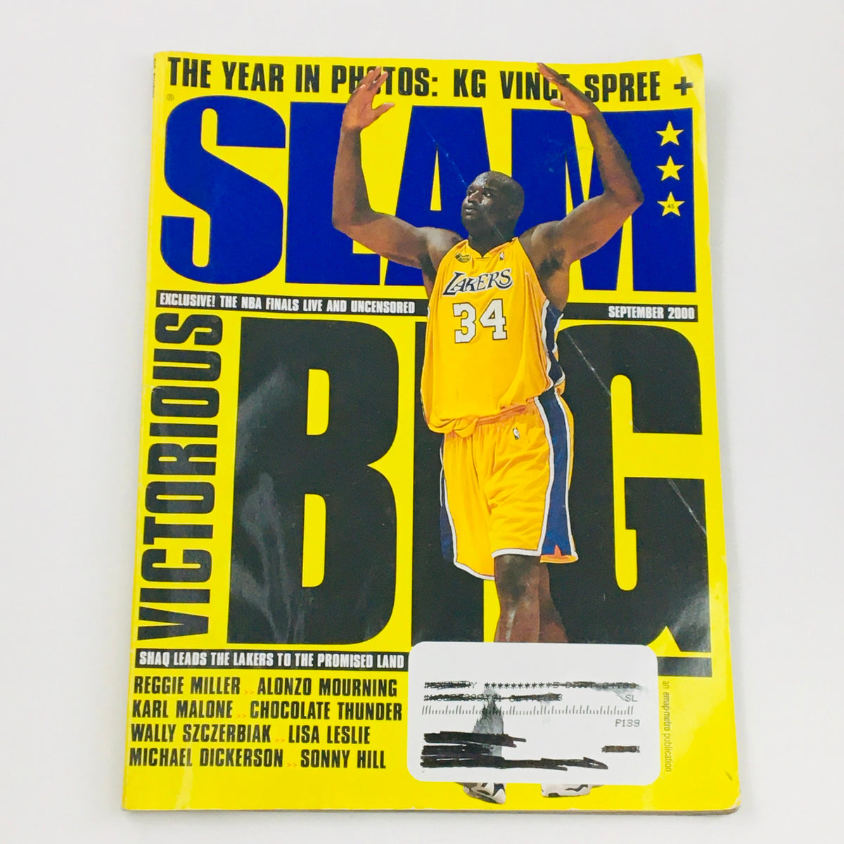 Slam Magazine September 2000 cover featuring LA Lakers' Shaquille O'Neal showcasing his iconic 34 jersey, celebrating with arms raised, highlighting basketball glory.