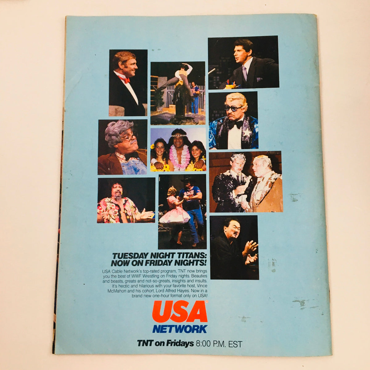 Back cover of WWF Magazine August 1985 promoting the USA Network's show 'Tuesday Night Titans', featuring icons from the wrestling world, demonstrating the blend of entertainment and sports.