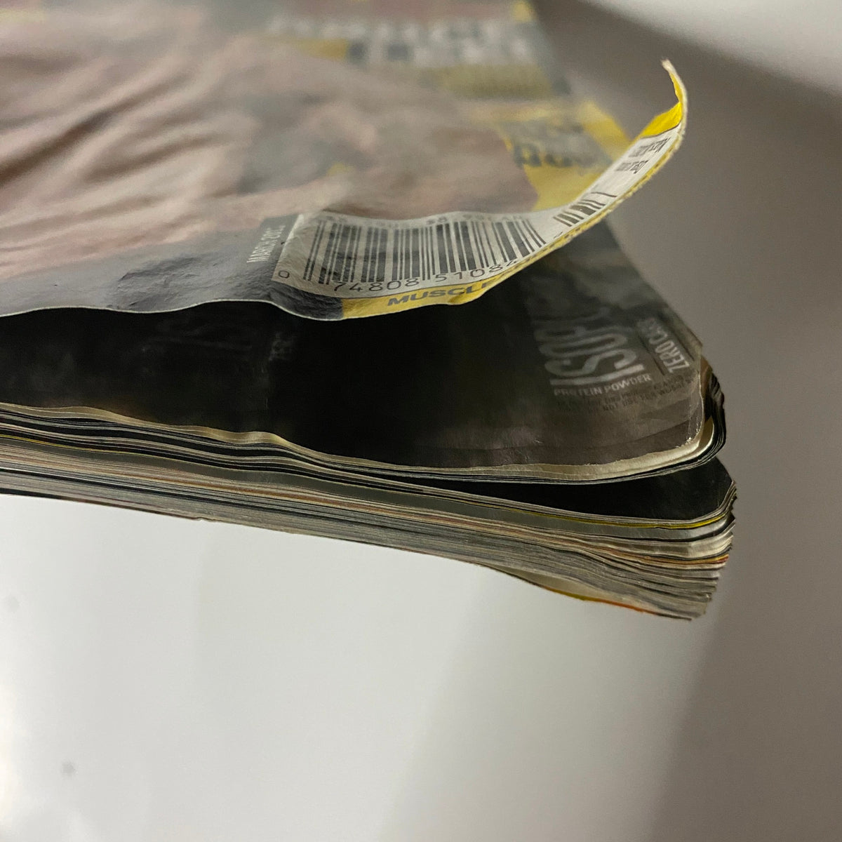 Close-up view of the spine and edge of the Muscle & Fitness Magazine March 2013 issue featuring Bruce Lee, highlighting the magazine's condition.