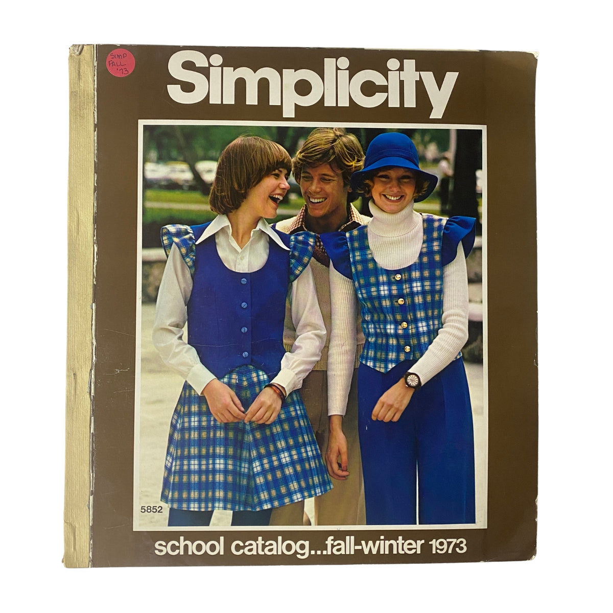 Cover of the 1973 Simplicity Fall and Winter School Catalog featuring three models in vintage blue plaid outfits, ideal for students and beginner sewers.