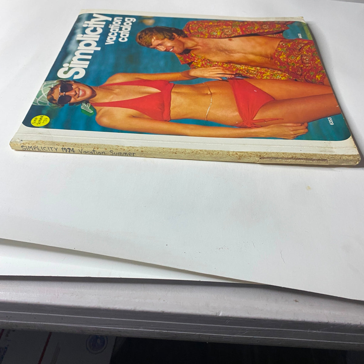 Side view of the 1974 Simplicity Summer Catalog emphasizing the title 'Simplicity 1974 Vacation Summer' with a couple in swimwear featured on the cover.