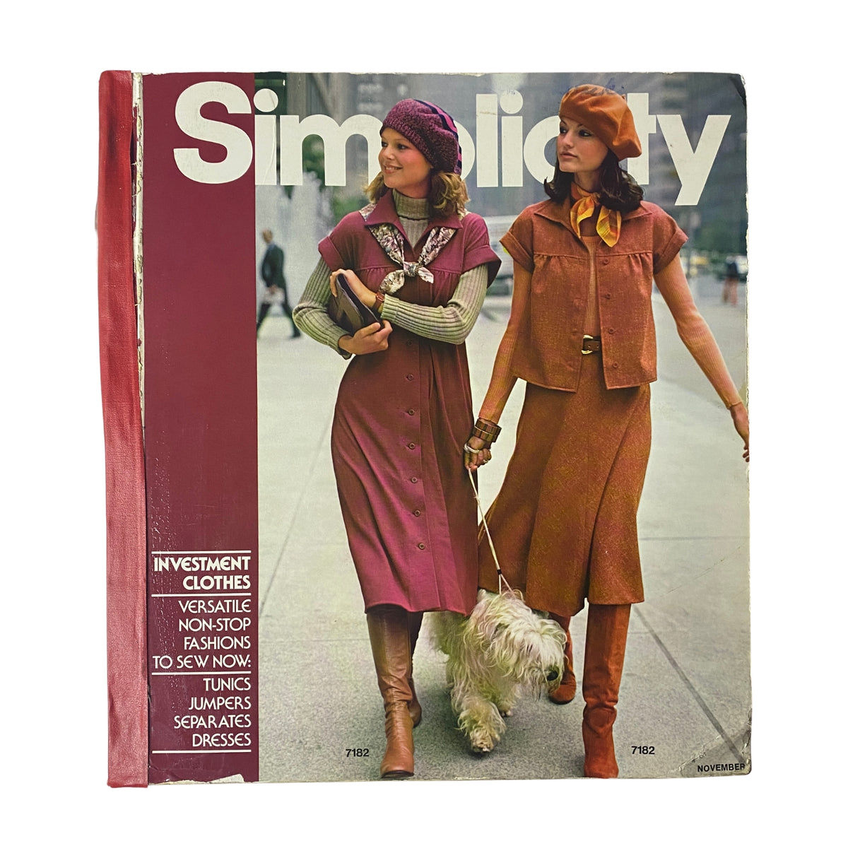 1975 November Simplicity Catalog cover featuring women dressed in stylish vintage fashions, showcasing investment clothes like tunics and jumpers with a dog in a city setting.