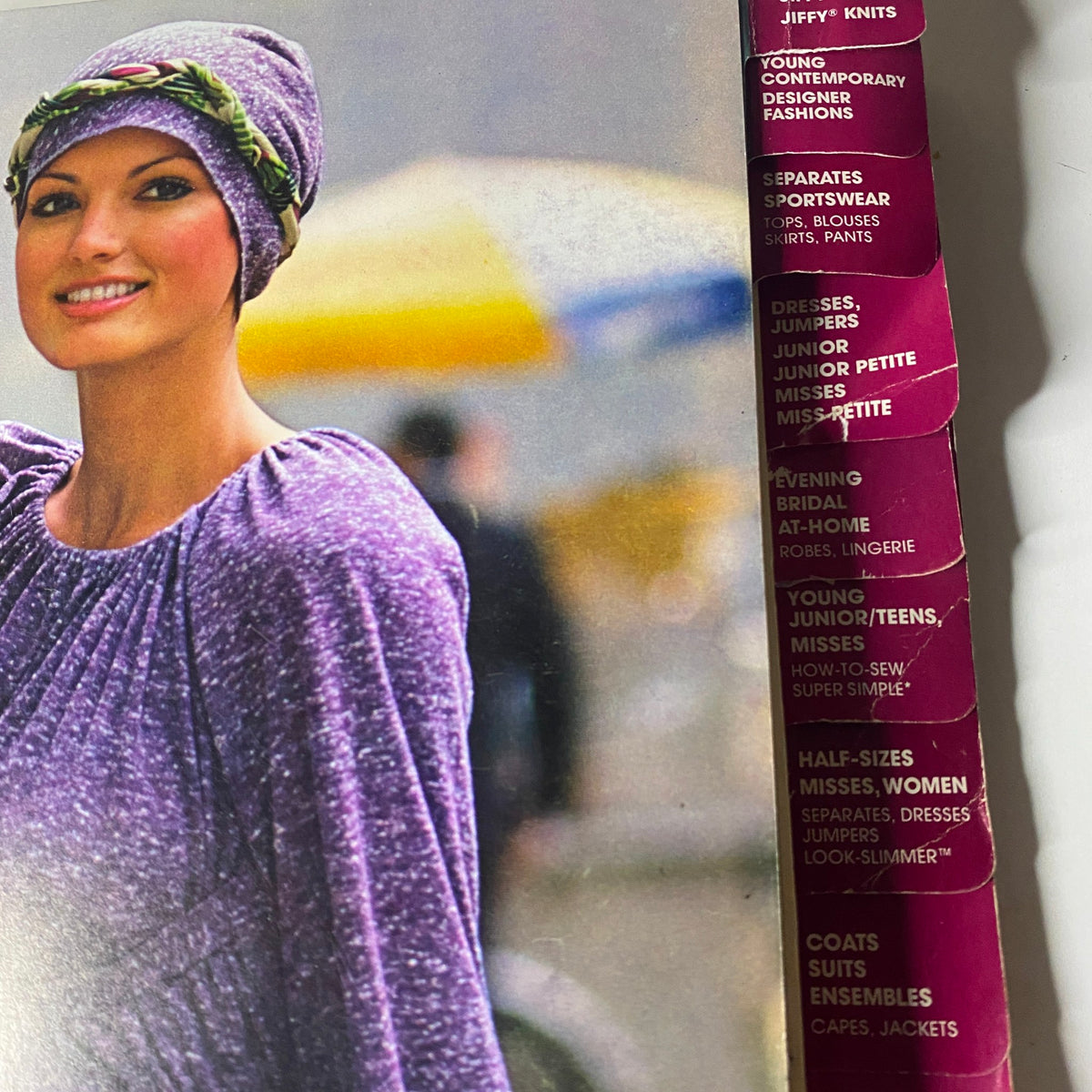 1975 November Simplicity Catalog showcasing a model in a purple outfit, highlighting contemporary design and fabric use.