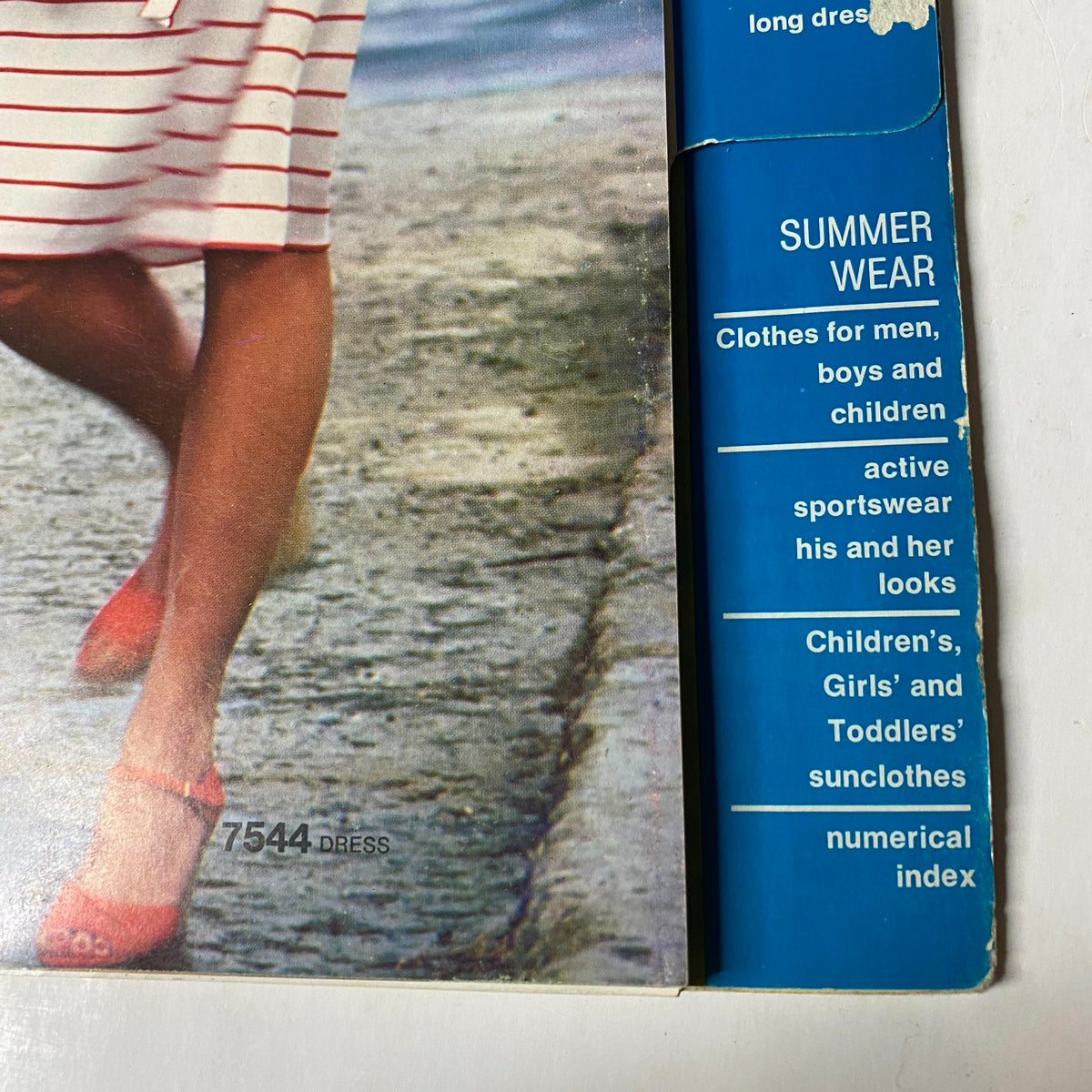 Cover page of the 1976 Simplicity Sportswear Catalog showcasing summer wear with a woman walking wearing a striped dress, emphasizing fashion for active, summer living.