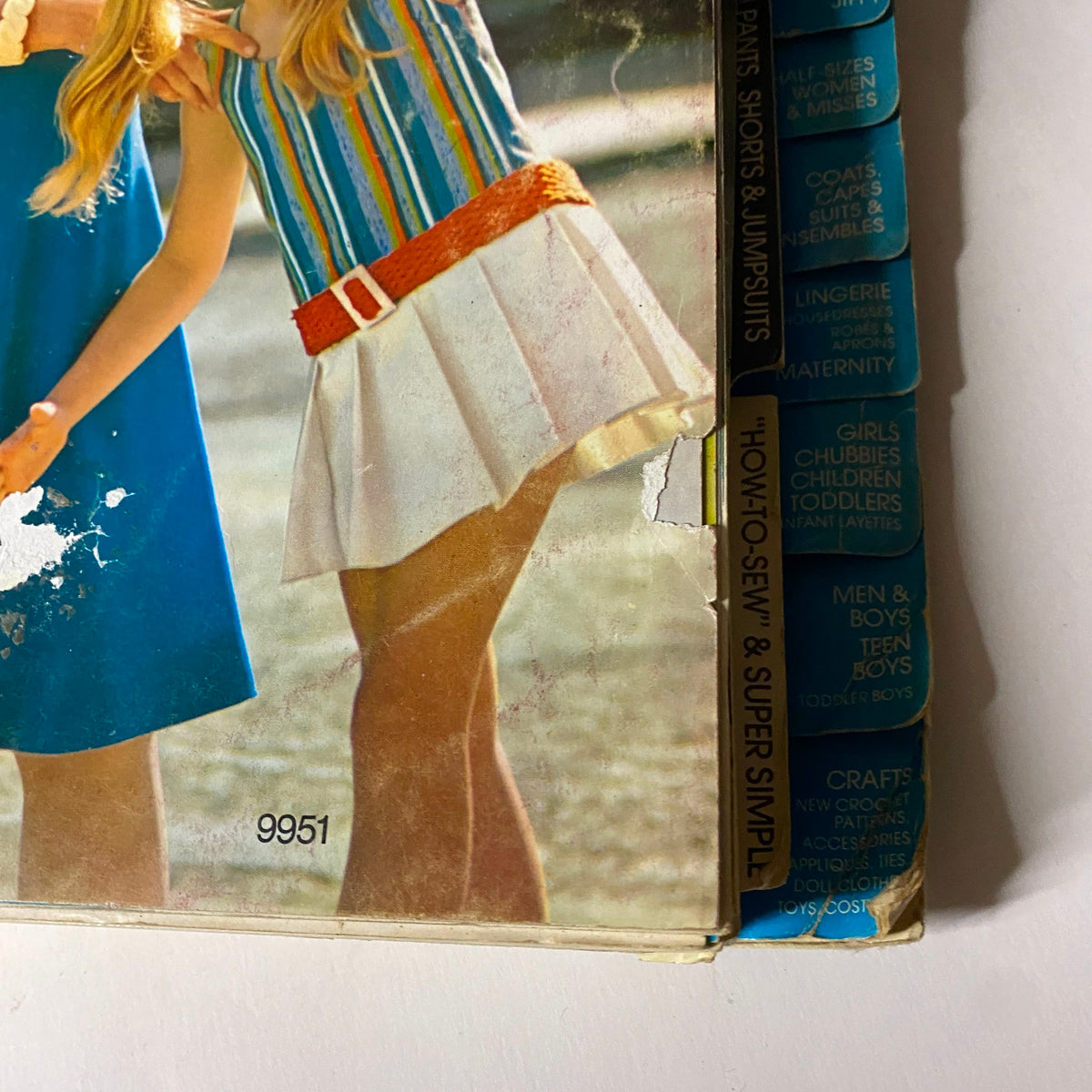 1970s May Simplicity Sewing Pattern Catalog Store Counter Book showing detailed sections for children's fashion, including a girl in a striped outfit and another in a stylish dress.