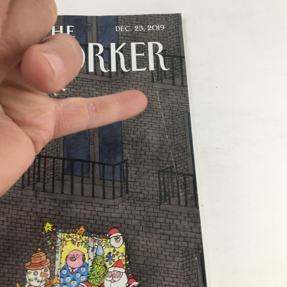 Close-up of The New Yorker magazine cover dated December 23, 2019, showing the corner of the magazine with festive characters and the title 'The New Yorker' prominently displayed.