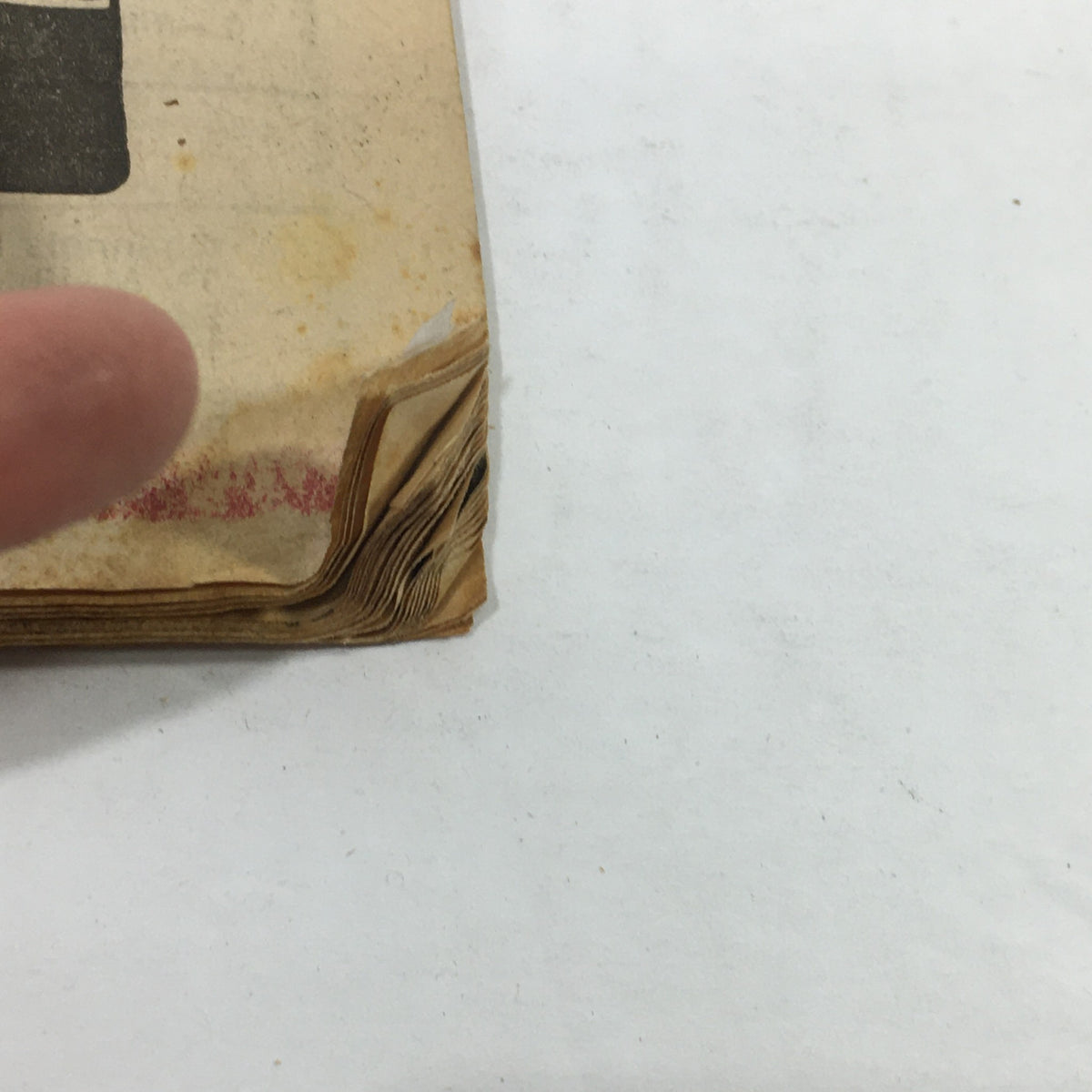 Side view of the vintage magazine 'VTG TV Dial Complete Cable Listings October 15-22 1977 Three's Company on ABC', highlighting edges with slight damage and a finger indicating wear.