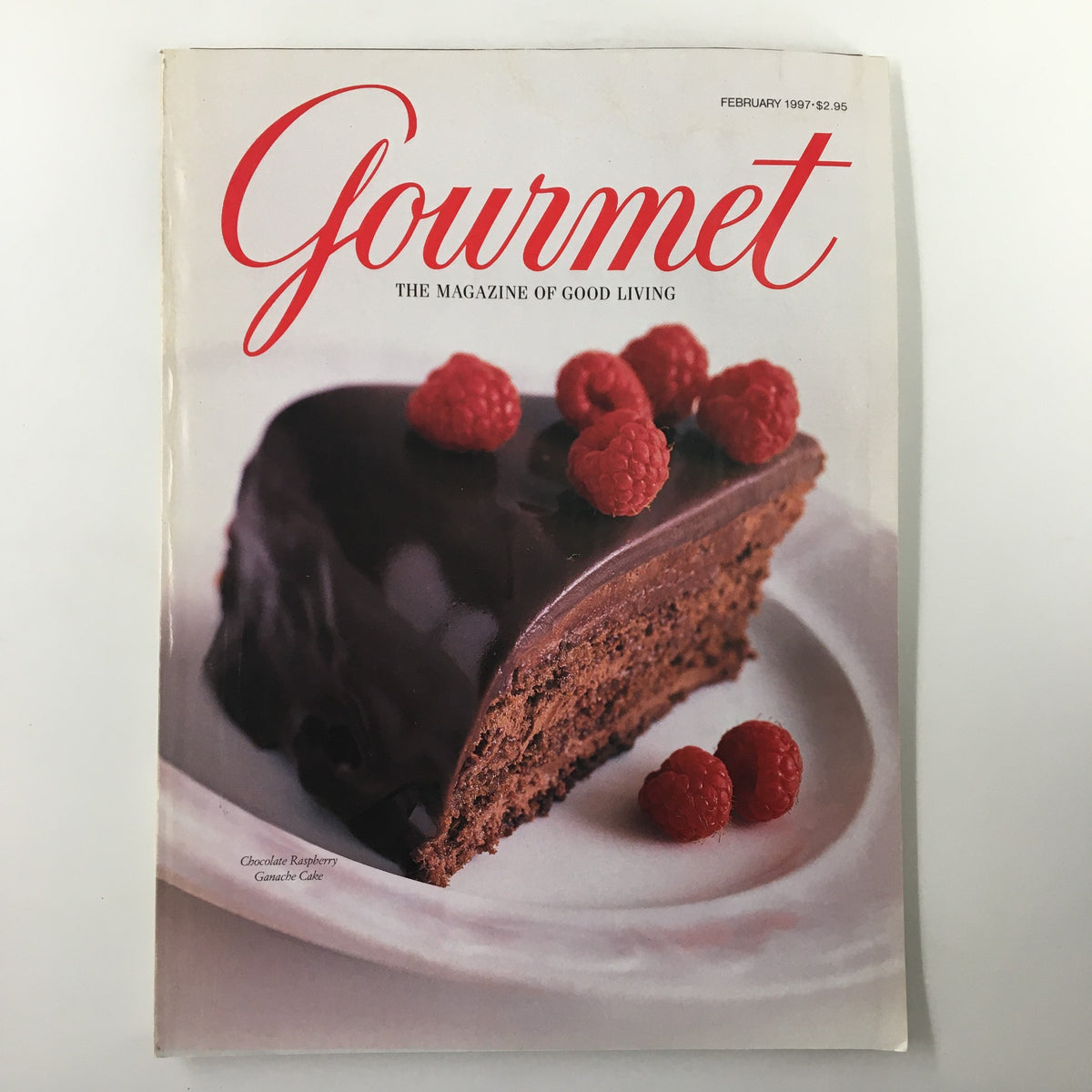 Cover of Gourmet Magazine February 1997 featuring a Chocolate Raspberry Ganache Cake topped with fresh raspberries, showcasing the exquisite dessert alongside the magazine's title.