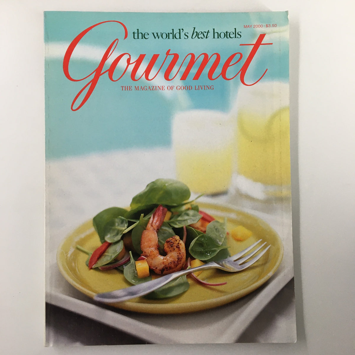 Cover of Gourmet Magazine May 2000 featuring a fresh salad with shrimp on a yellow plate, highlighting the theme of luxury dining and travel.