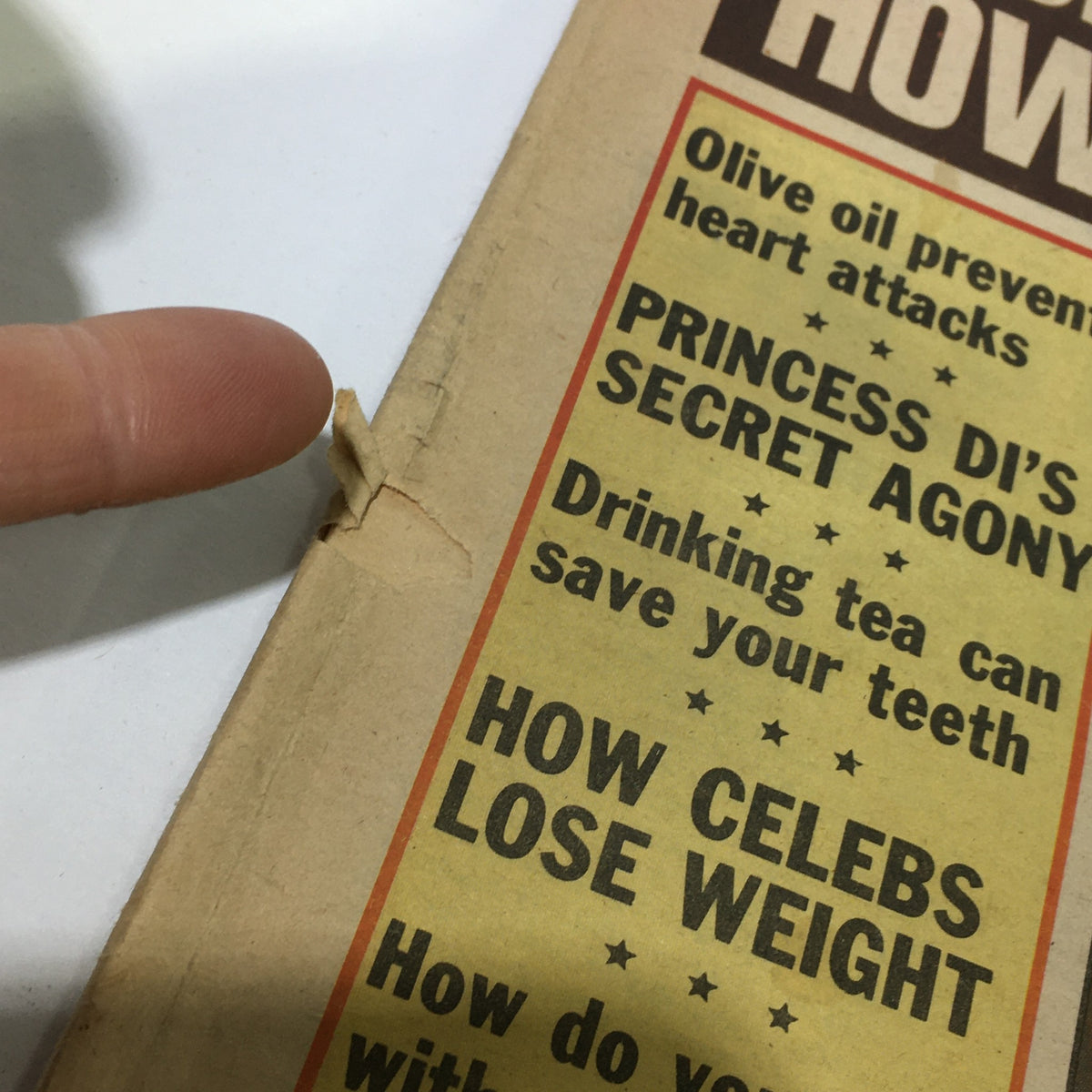 Close-up view of the cover of the VTG National Examiner Magazine July 27 1982, highlighting wear and tear, including a visible rip, while showcasing headlines about celebrity health and life longevity.