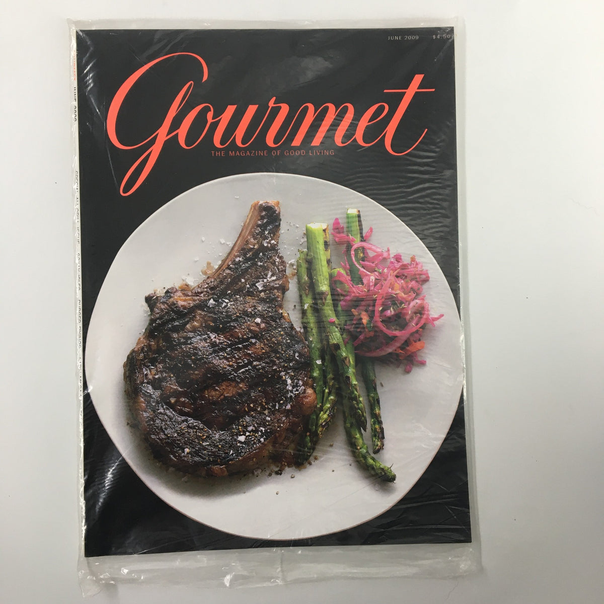 Gourmet Magazine June 2009 cover featuring a grilled ribeye steak alongside sautéed asparagus and pickled red onions, showcasing a vibrant culinary presentation.
