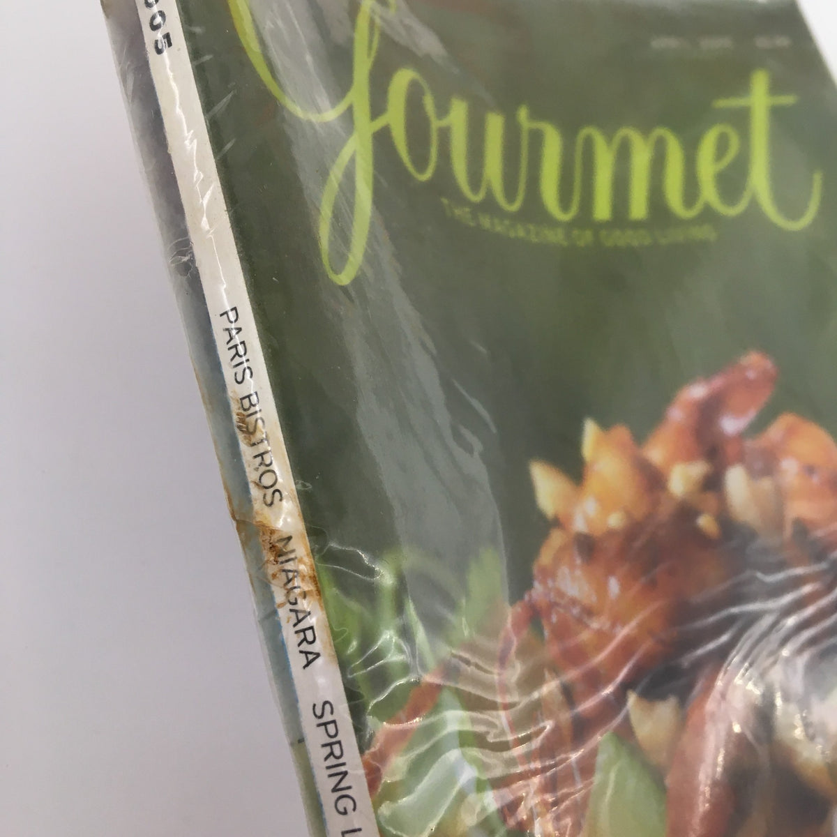 Side view of Gourmet Magazine April 2005 highlighting the features 'Paris Bistros', 'Niagara', and 'Spring', in its original packaging, emphasizing the magazine's new condition.