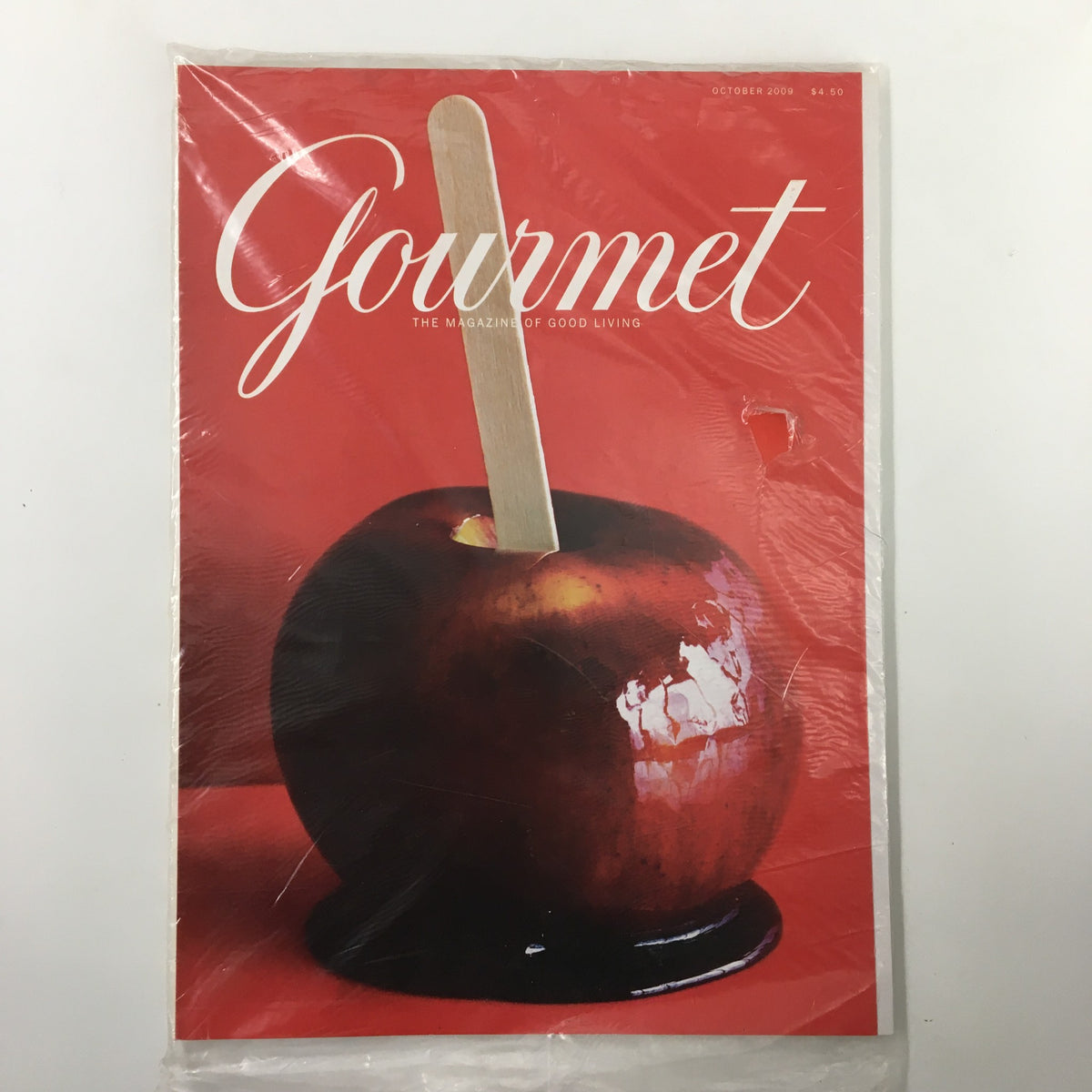 Gourmet Magazine October 2009 issue featuring Red Wine Caramel Apples recipe, sealed with plastic covering, showcasing a glossy red apple covered in caramel.