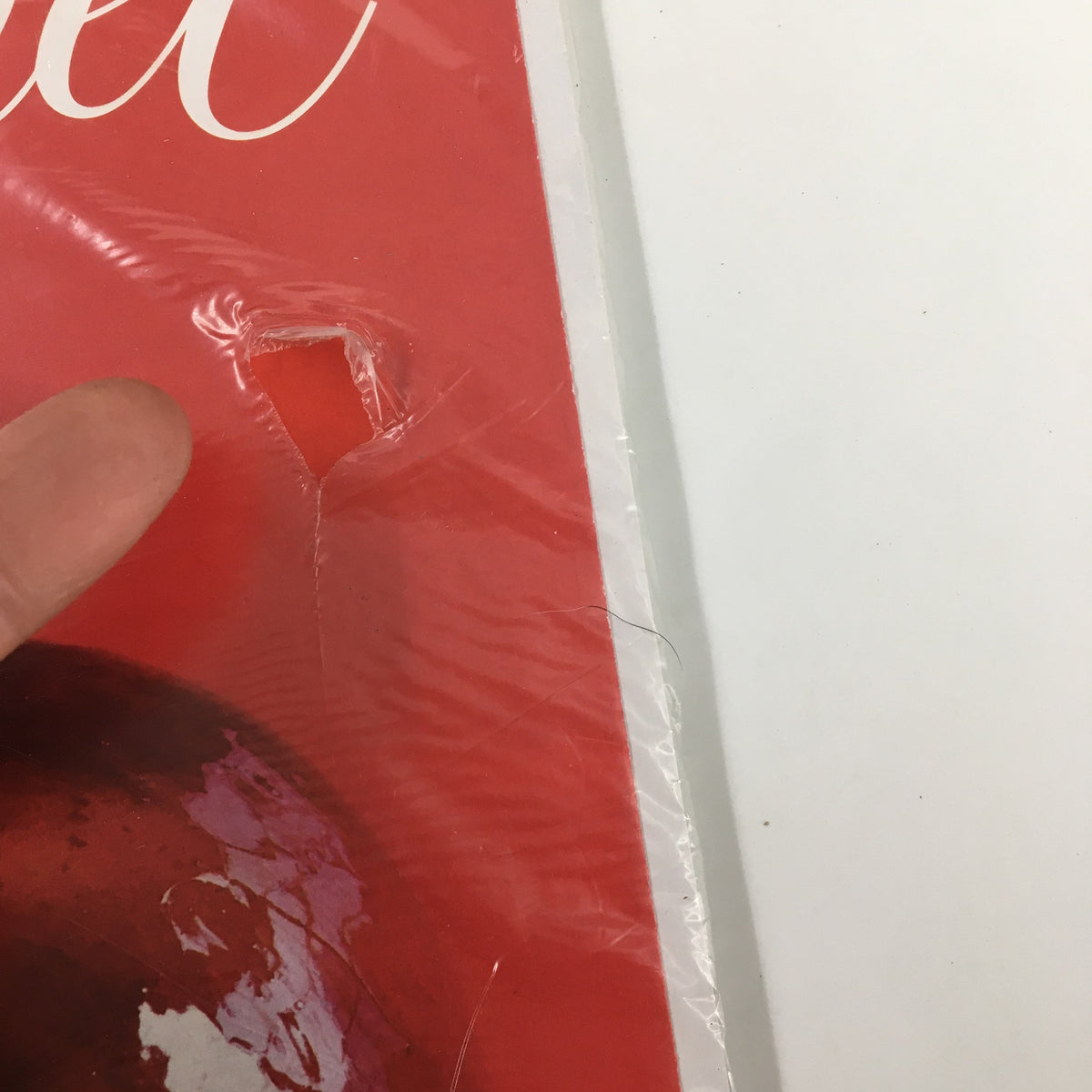 Close-up of the Gourmet Magazine October 2009 issue showing a small hole in the plastic covering, highlighting the vintage design and wrapping.