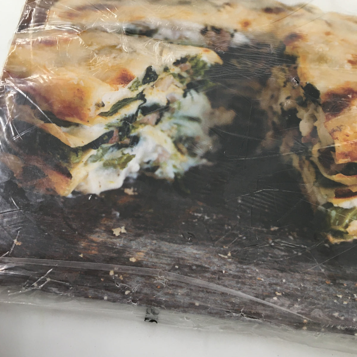 Close-up image of Baked Eggs in Cream with Spinach dish featured in Gourmet Magazine January 2007, showcasing delicious layers of spinach and cream.