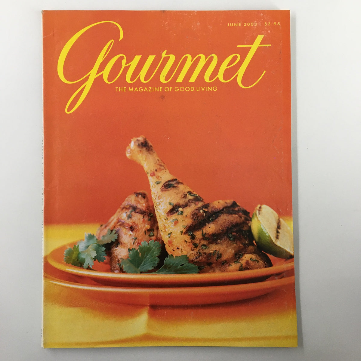 Cover of Gourmet Magazine June 2003 featuring grilled chicken legs on an orange background, highlighting culinary creativity with a menu of spiced skirt steak.