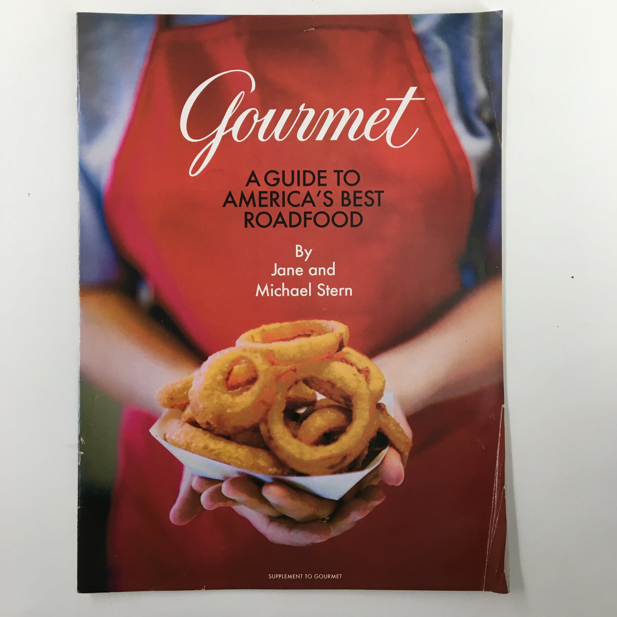 Cover of Gourmet Magazine November 2003, titled 'A Guide to America's Best Roadfood', featuring a hand holding a plate of onion rings, symbolizing American roadside cuisine.