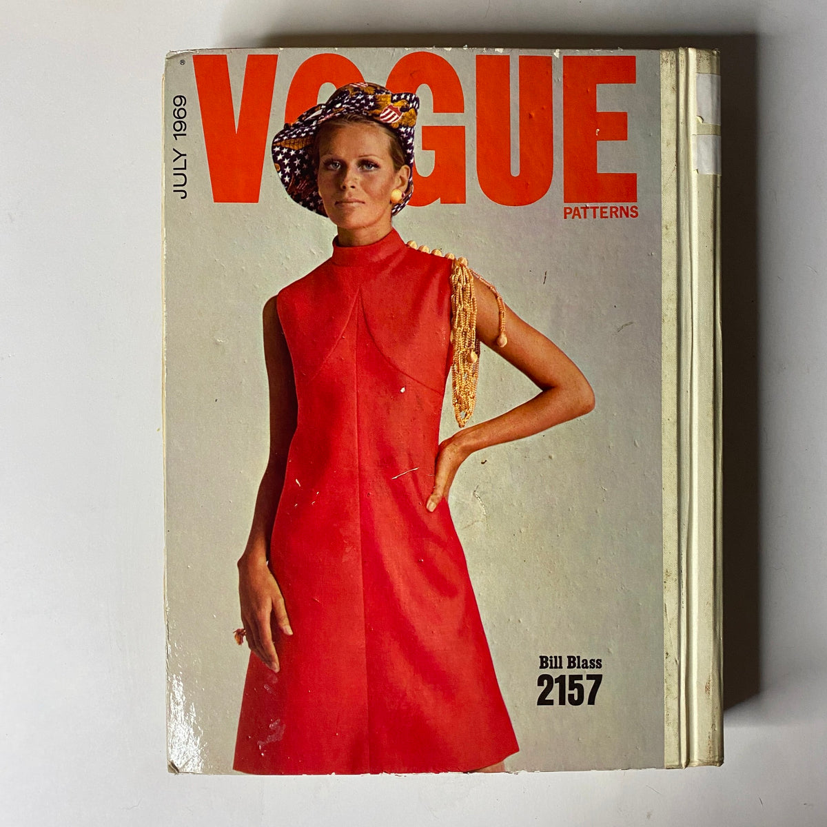 1969 Vogue Patterns July Catalog cover showcasing a model in a striking red dress, embodying the fashion essence of the late 1960s with bold colors and modern design.