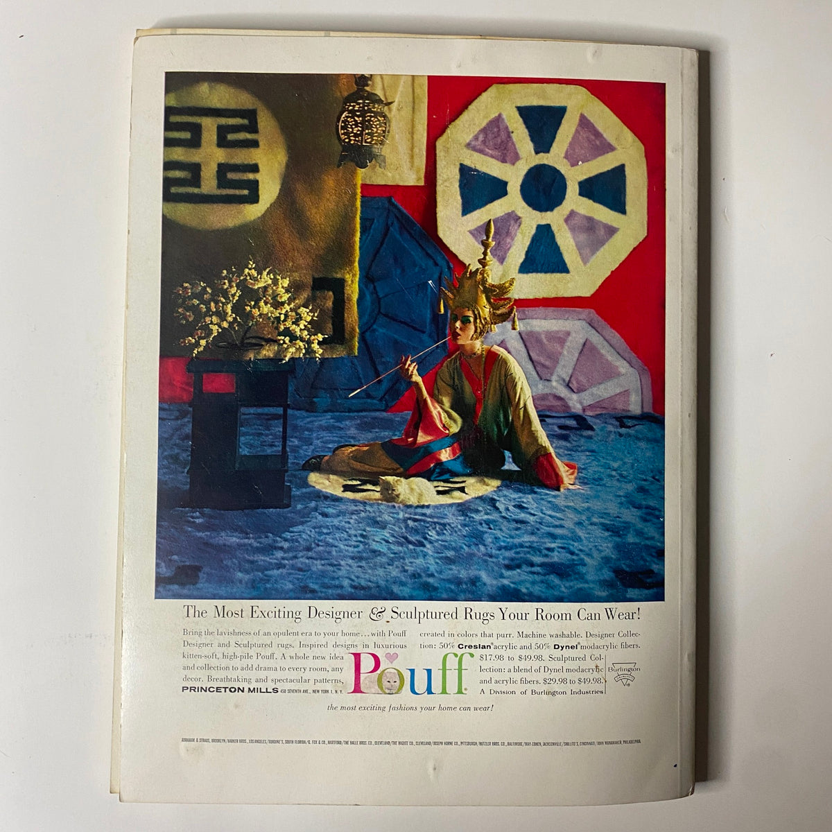 1961 American Fabrics No. 53 Summer Catalog page featuring a vibrant advertisement for Pouff designer and sculptured rugs. The image showcases a model dressed in elaborate attire, set against a colorful background featuring geometric shapes and decorative elements that highlight the artistry of mid-century textile design.