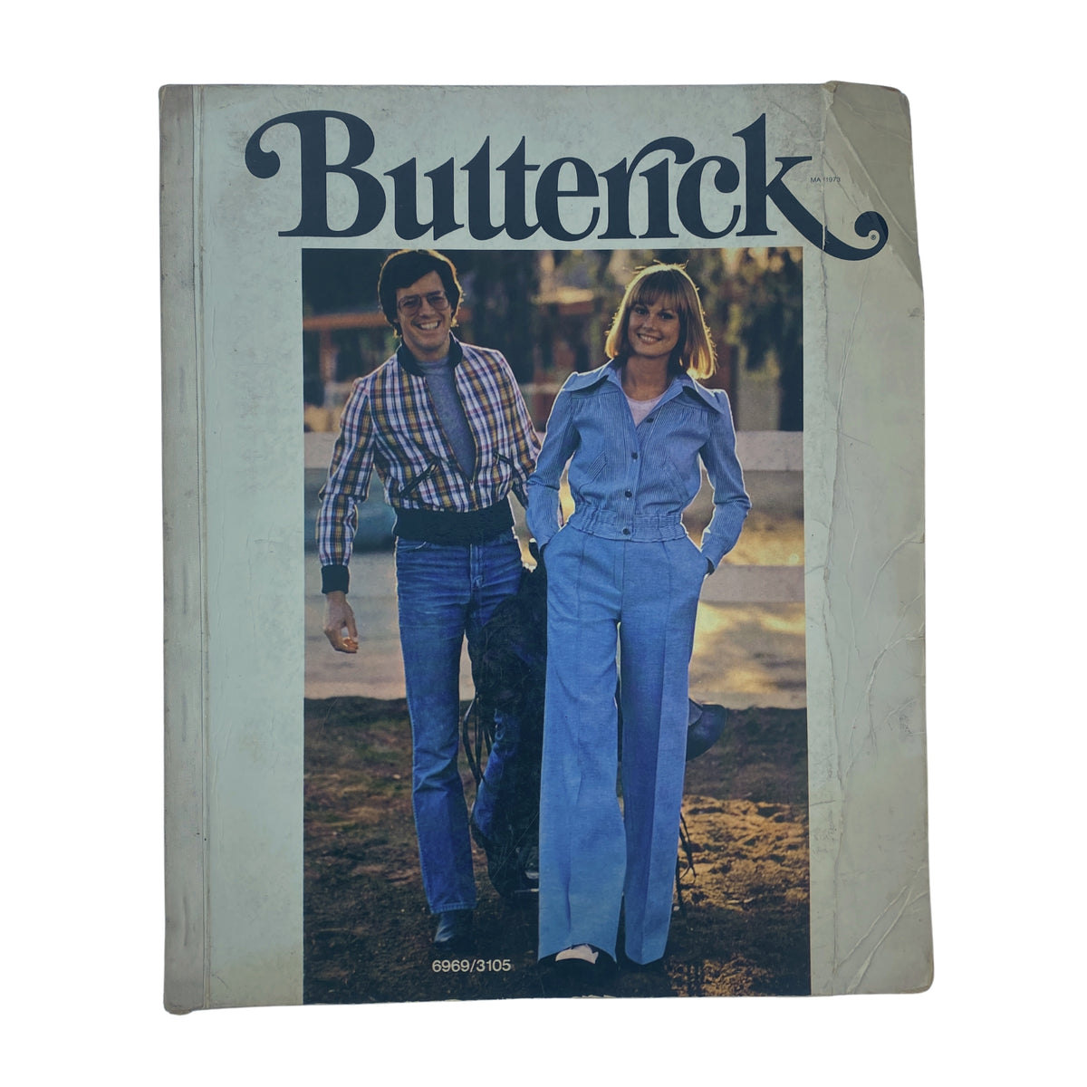 Cover of the 1973 May Butterick Catalog featuring a man and woman in retro clothing, showcasing the fashion styles of the early 1970s.