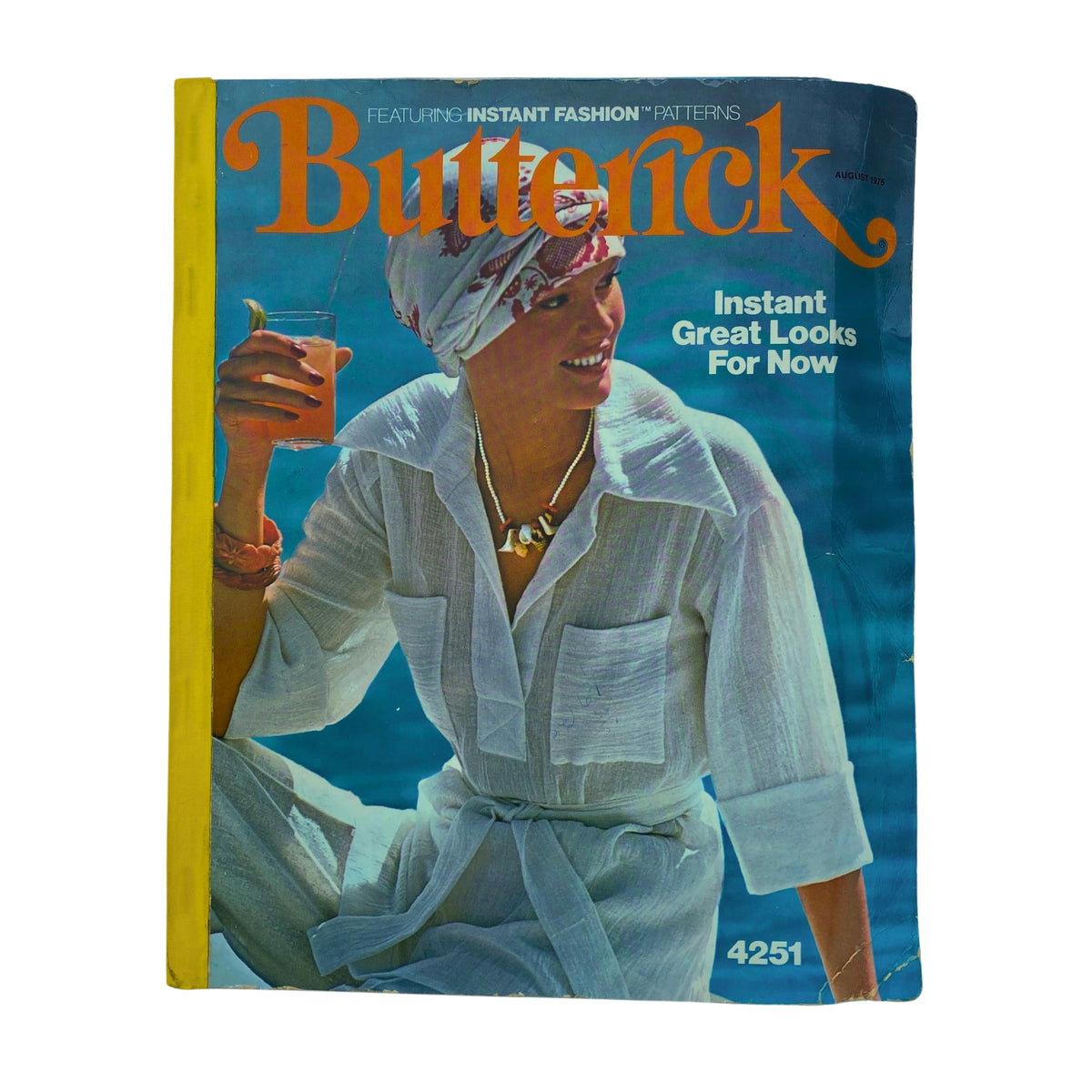 Cover of the 1975 August Butterick Catalog featuring a woman wearing a white gauzy outfit, showcasing instant fashion patterns for summer and fall.