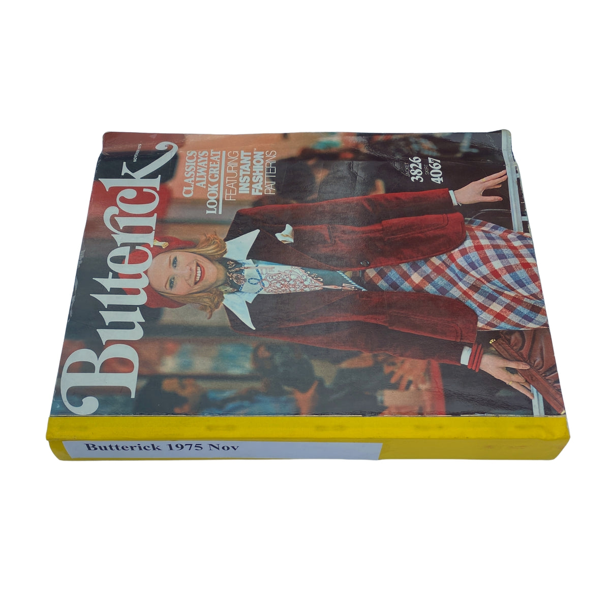 Cover of the 1975 November Butterick Catalog showcasing vintage fashion patterns, featuring a smiling model in a stylish outfit with bright colors.