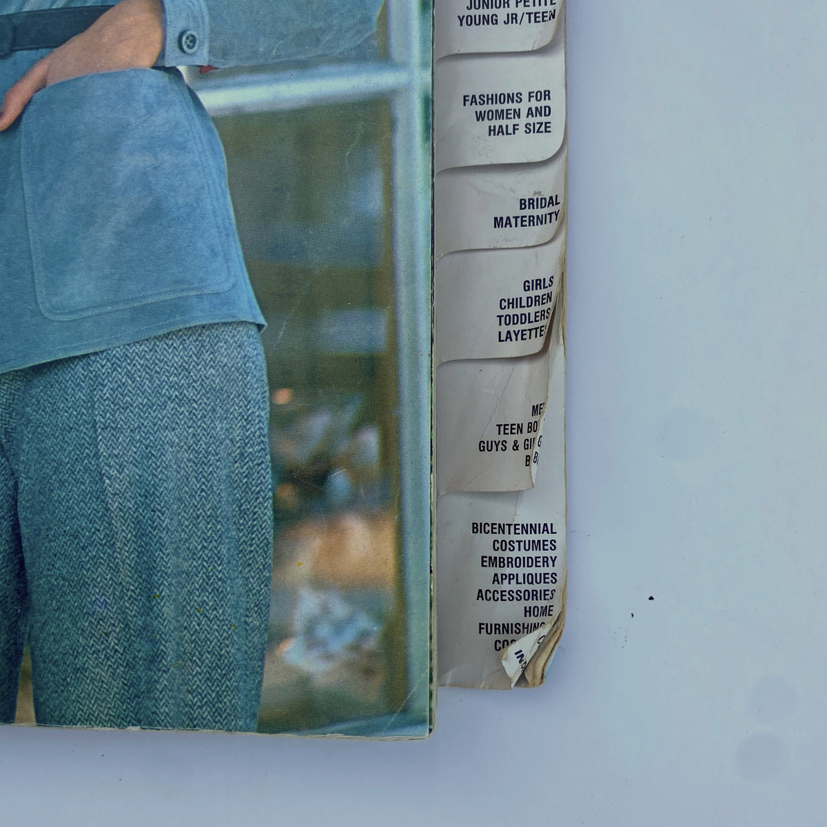 Detail image from the 1975 November Butterick Catalog emphasizing various fashion categories including bridal and children's styles, showcasing a model in a trendy outfit.