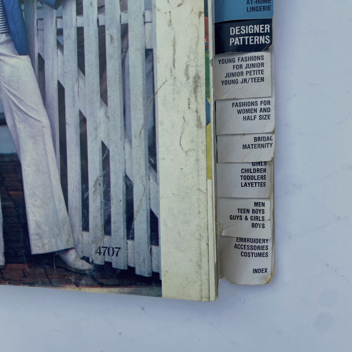Close-up of the tabbed sections of the 1976 April Butterick Catalog highlighting categories such as designer patterns, maternity, and children's wear.