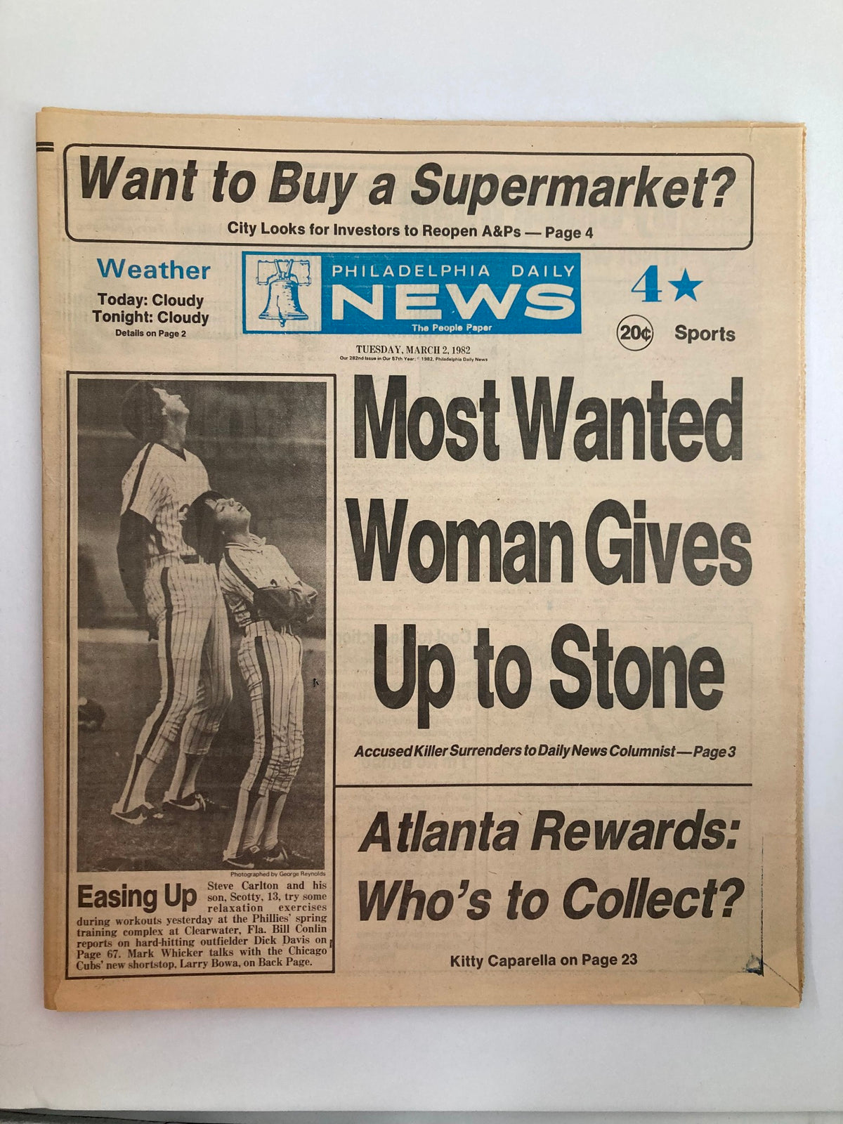 Philadelphia Daily News Tabloid from March 2, 1982, featuring the headline 'Most Wanted Woman Gives Up to Stone'. The image displays a photograph of two baseball players, highlighting the Philadelphia Phillies. The tabloid includes sections on weather and sports.
