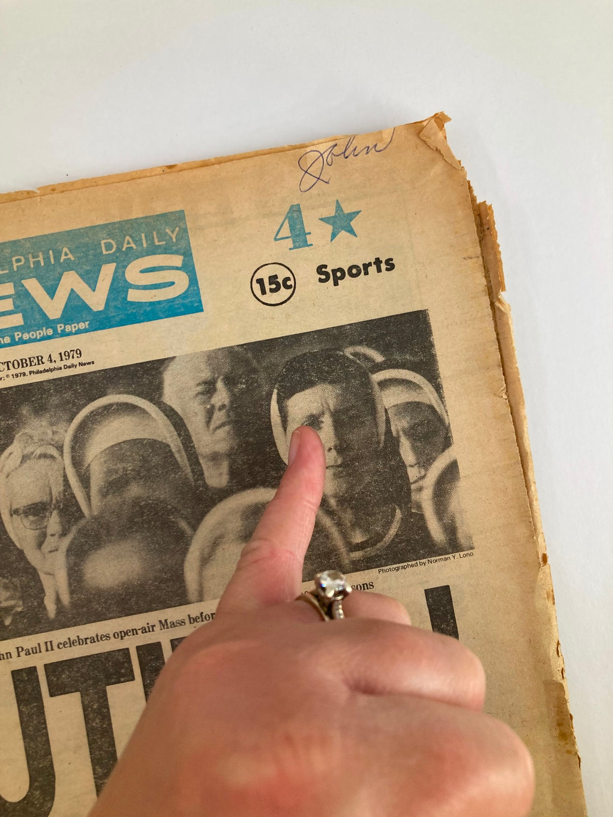 Close-up image of the Philadelphia Daily News Tabloid from October 4 1979 showing a woman's hand pointing at a detail of Pope John Paul II's visit, emphasizing engagement with the historic event.