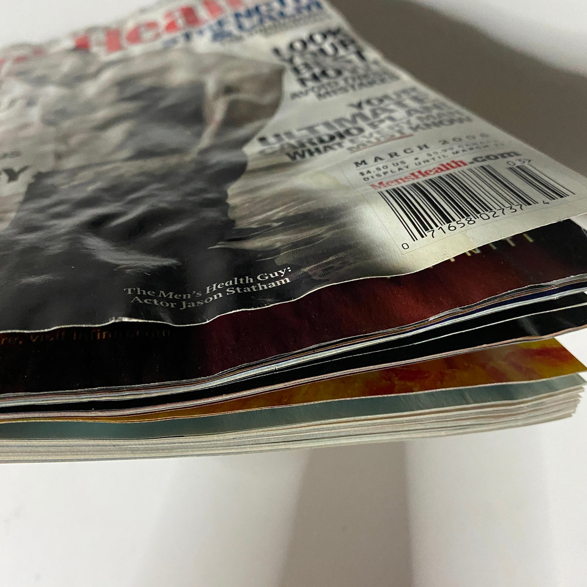 Side view of Men's Health Magazine, March 2006 edition featuring actor Jason Statham on the cover, showcasing the magazine's aged spine and pages.