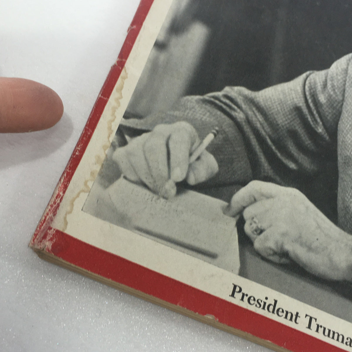 Close-up view of a vintage Newsweek magazine dated May 28, 1945, showing wear on the edge and a hand pointing at the text about President Truman.