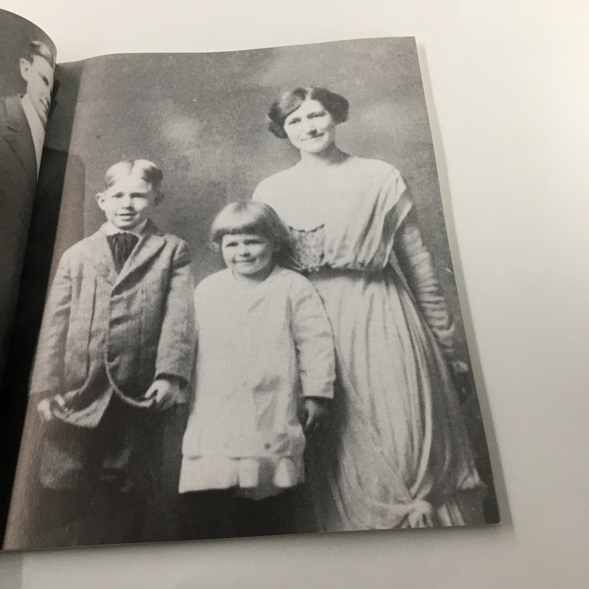 Historical photograph inside 'A Tribute To Reagan 1911 - 2004', depicting a young Ronald Reagan with two children, illustrating his early life.