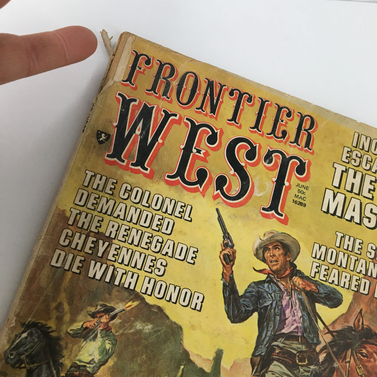 Close-up view of Frontier West Magazine June 1971 Vol. 1 #2 cover emphasizing the title 'The Sioux Massacre' and illustrations depicting frontier life.