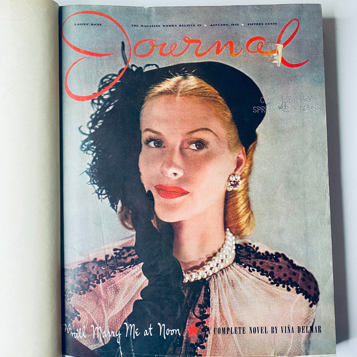 Cover of Ladies' Home Journal January 1945 featuring a woman in a glamorous outfit with a feathered hat and pearl necklace, presenting the title 'Will Marry Me at Noon' - part of the 1945 library bound magazine collection.