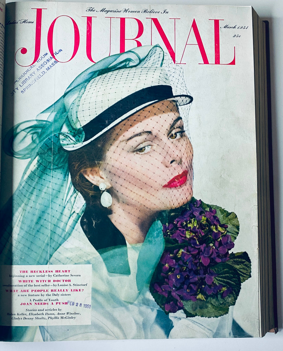 Cover of Ladies' Home Journal March 1951 featuring an elegant woman with a floral arrangement, showcasing classic 1950s fashion.