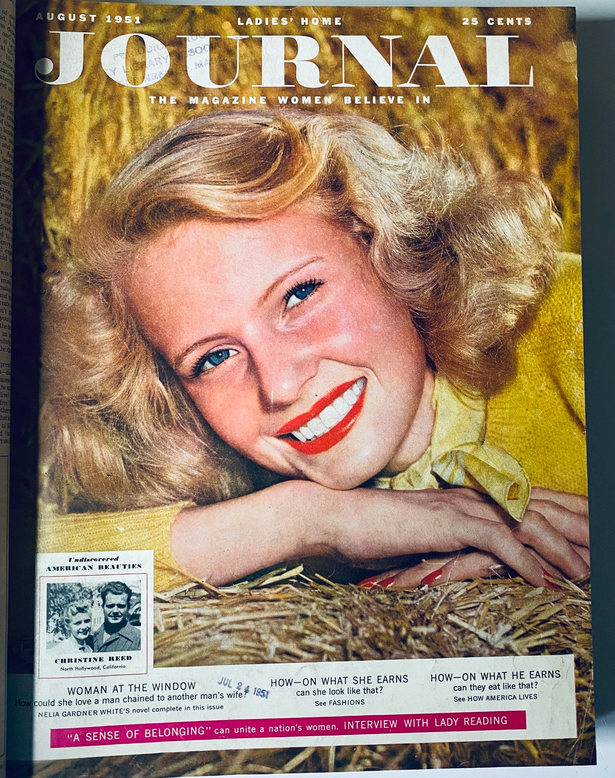 Cover of Ladies' Home Journal August 1951 magazine featuring a joyful woman with blond hair resting on straw, exuding happiness and style. This image reflects the vibrant fashion and lifestyle aspects of the time.