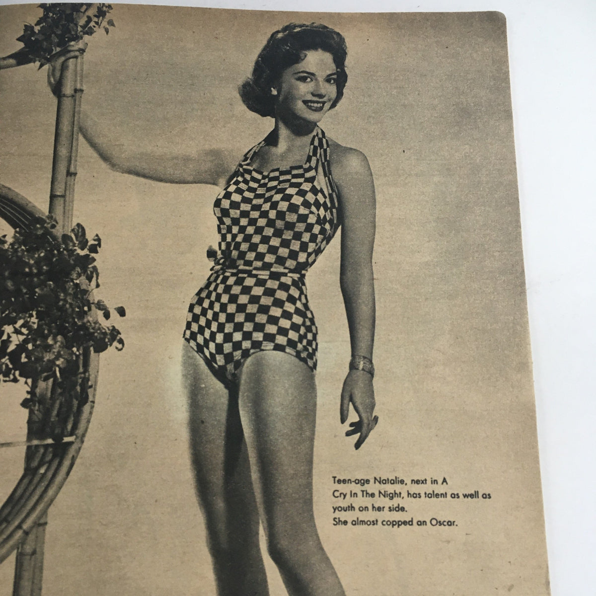 Black and white photograph of teenage Natalie Wood in a stylish checkered swimsuit, from Hollywood Stars Magazine October 1956, showcasing her youthful talent and beauty.