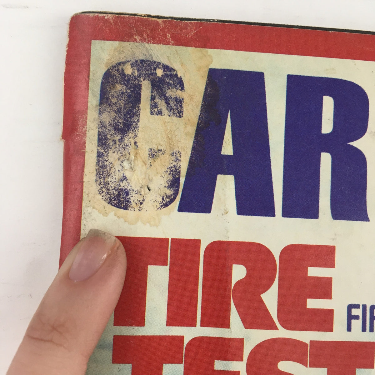 Close-up view of the Car and Driver Magazine June 1973 cover, highlighting the wear and age details, including the iconic title 'Tire Test' and markings from past circulation.