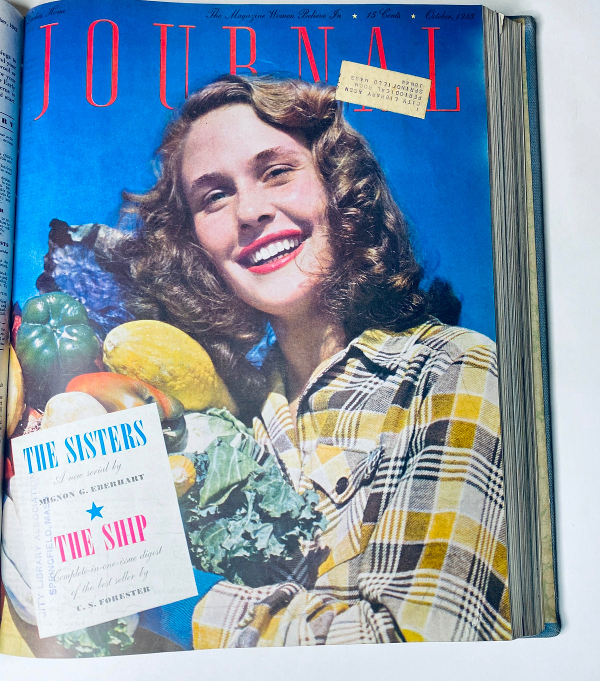 Cover of Ladies' Home Journal, October 1943 edition, featuring a woman holding vegetables with a bright blue background, promoting 'The Sisters' novel by Mignon G. Eberhart.