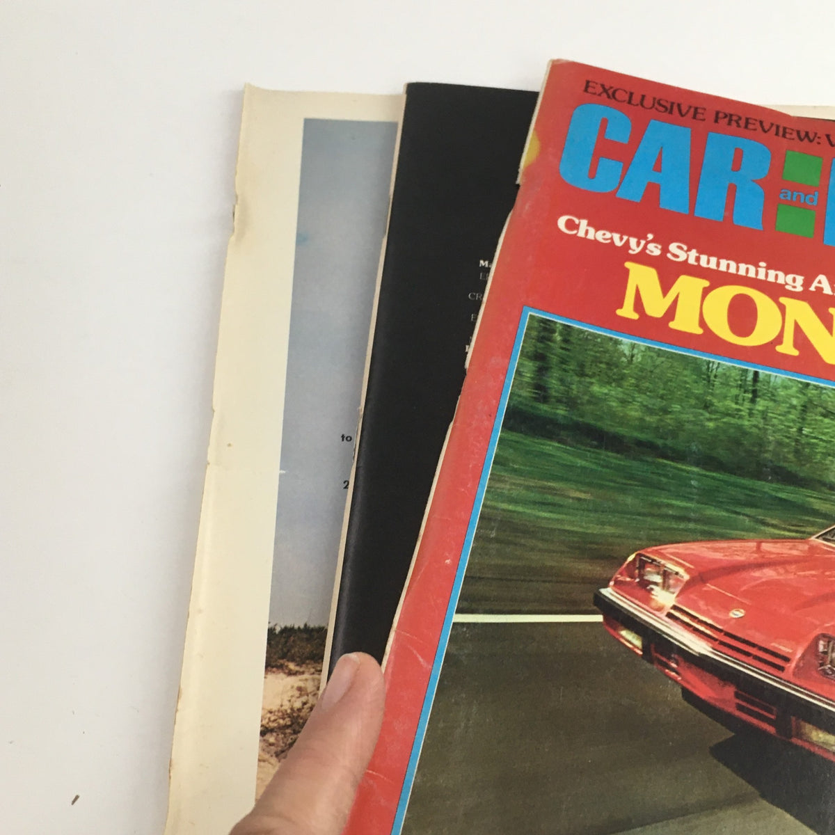 Side view of Car and Driver Magazine, September 1974 edition, displaying the front cover featuring the Ford Mustang II Monza 2+2, held in hand, with hints of other pages visible.