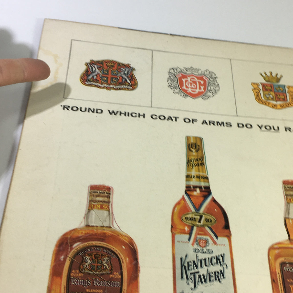 Vintage advertisement featuring various coats of arms and whiskey bottles from the Sports Illustrated Magazine February 11, 1957 - The Epic of Spike Webb. This image showcases branding and vintage graphics related to collectible spirits.