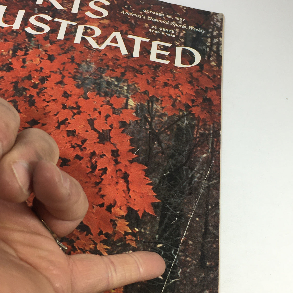 Detailed view of the cover of the vintage Sports Illustrated Magazine from October 28, 1957, showcasing the title 'A Walk Into Autumn' against colorful autumn leaves.