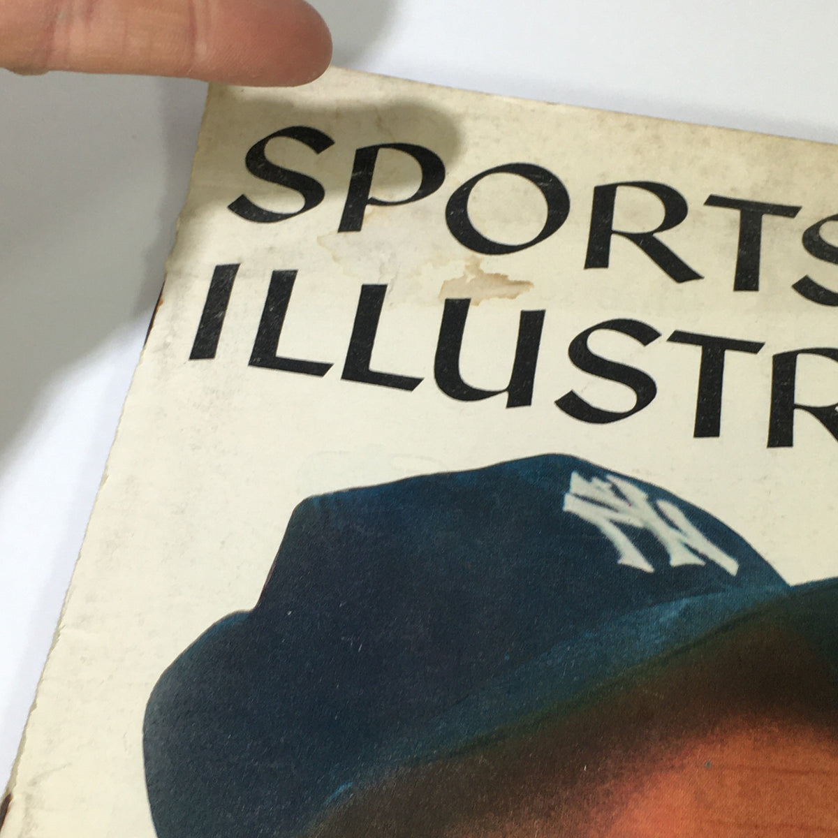 Close-up of the Sports Illustrated Magazine cover from July 22, 1957, focusing on the title and Hank Bauer's Yankees cap, representing classic baseball history.