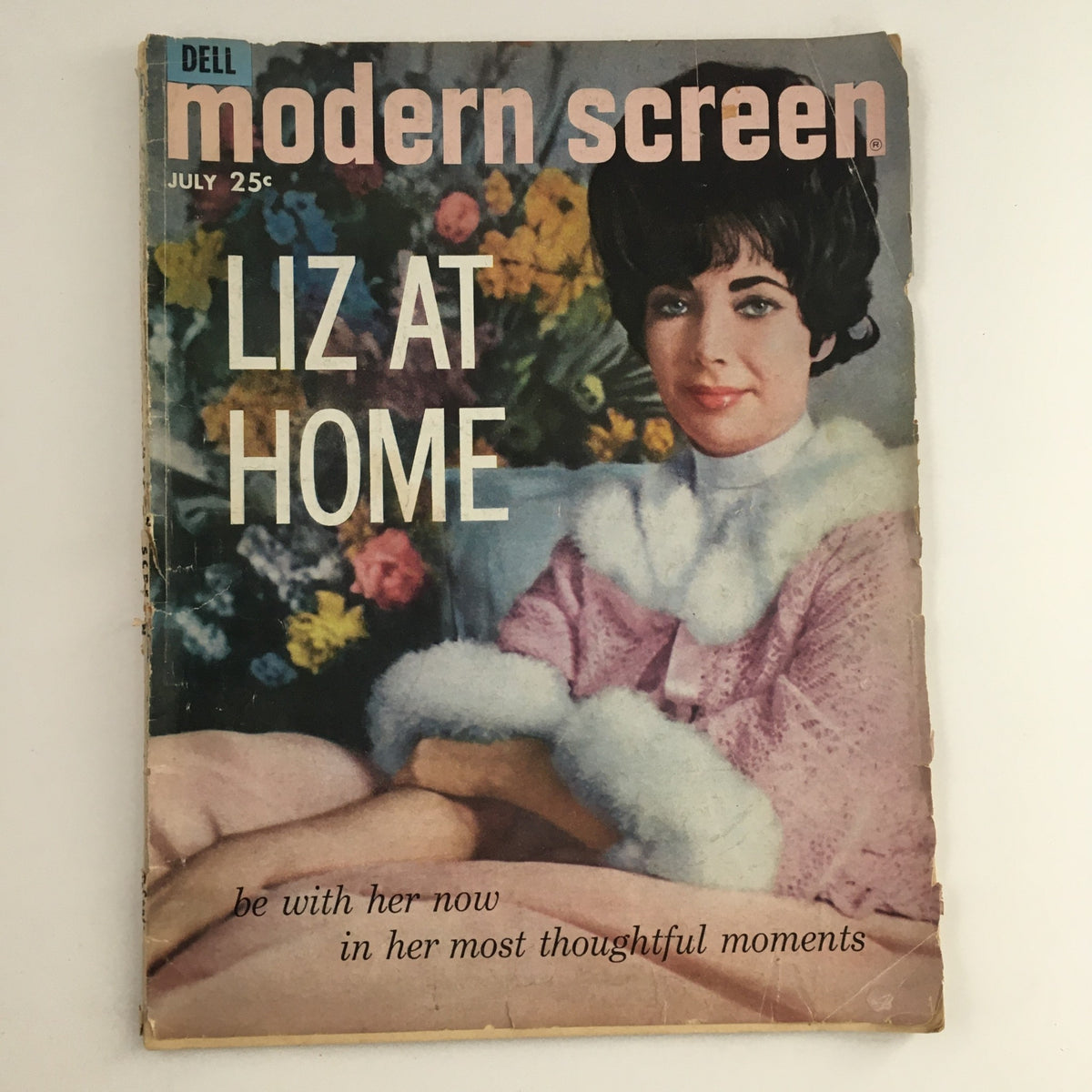 Cover of Modern Screen Magazine from July 1961, featuring Elizabeth Taylor in a fur-trimmed outfit, titled 'Liz at Home' with a floral background.