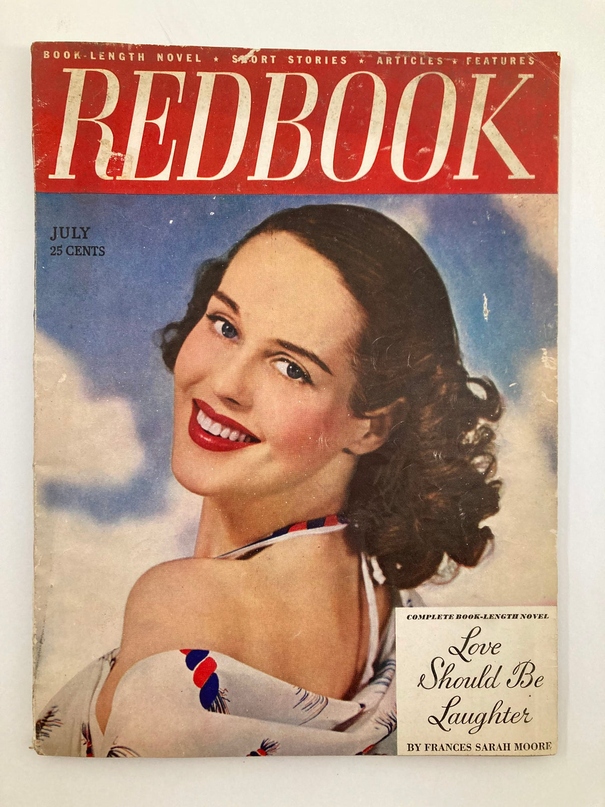 Cover of VTG Redbook Magazine July 1949 featuring the theme 'Love Should Be Laughter,' showcasing a smiling woman with curly hair and a vintage fashion background.